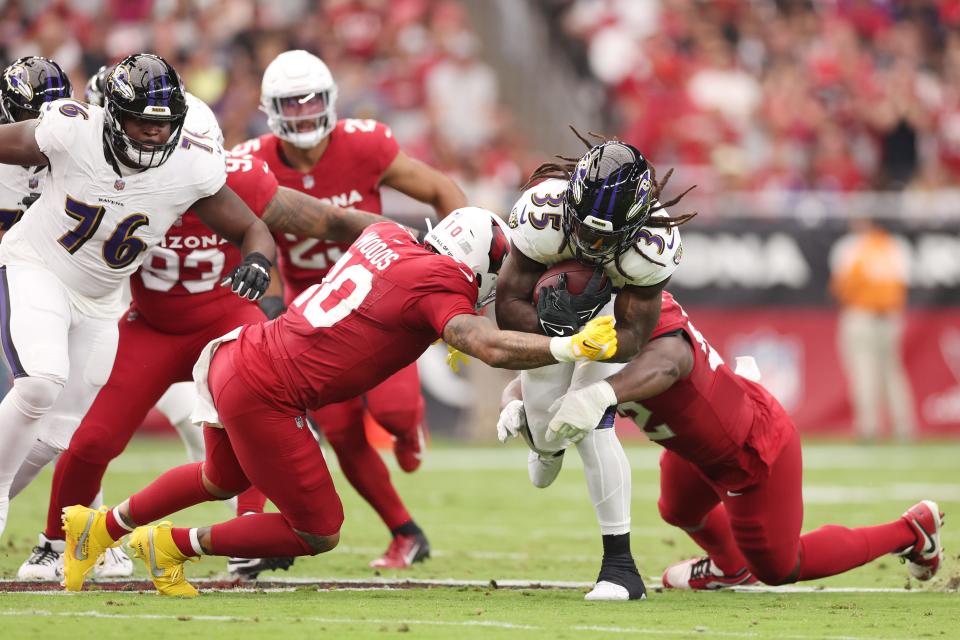 GLENDALE, ARIZONA - OCTOBER 29: Josh Woods #10 of the Arizona Cardinals tackles Gus Edwards #35 of the Baltimore Ravens during the first quarter at State Farm Stadium on October 29, 2023 in Glendale, Arizona. (Photo by Christian Petersen/Getty Images)