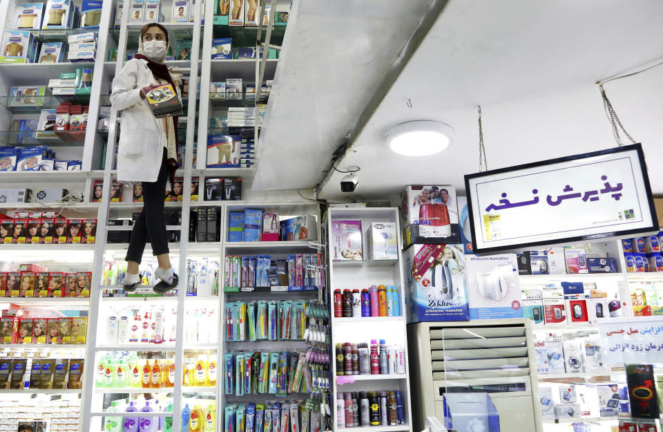 A pharmacist works in a drugstore in downtown Tehran, Iran, Tuesday, Feb. 25, 2020. The head of Iran's counter-coronavirus task force has tested positive for the virus himself, authorities announced Tuesday, showing the challenges facing the Islamic Republic amid concerns the outbreak may be far wider than officially acknowledged. The announcement comes as countries across the Mideast say they've had confirmed cases of the virus that link back to Iran, which for days denied having the virus. (AP Photo/Ebrahim Noroozi)