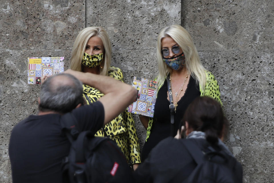 Two guests pose for photographers prior to the Dolce & Gabbana 2021 women's spring-summer ready-to-wear collection during the Milan's fashion week in Milan, Italy, Wednesday, Sept. 23, 2020. (AP Photo/Luca Bruno)