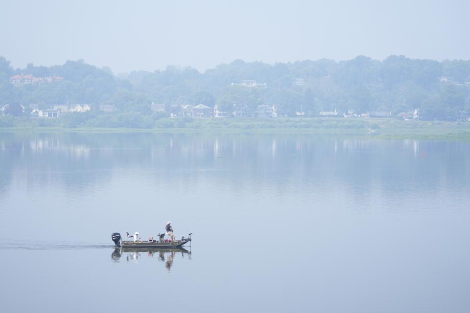 FILE - People fish on the Susquehanna River amidst haze from Canadian wildfires, June 29, 2023, in Harrisburg, Pa. As smoky as the summer has been so far, scientists say it will likely be worse in future years because of climate change. (AP Photo/Matt Rourke, File)