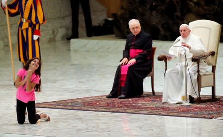 Pope Francis allows a little girl suffering from an undisclosed illness to move around undisturbed clapping and dancing on the stage for most of his general audience in Paul VI Hall at the Vatican