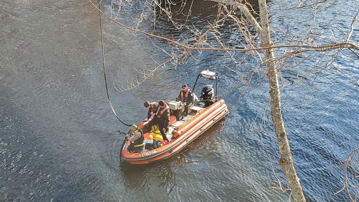 Crews ran copper wire across the Nashwaak River in an effort to restore internet connection.  (Bell Aliant - image credit)