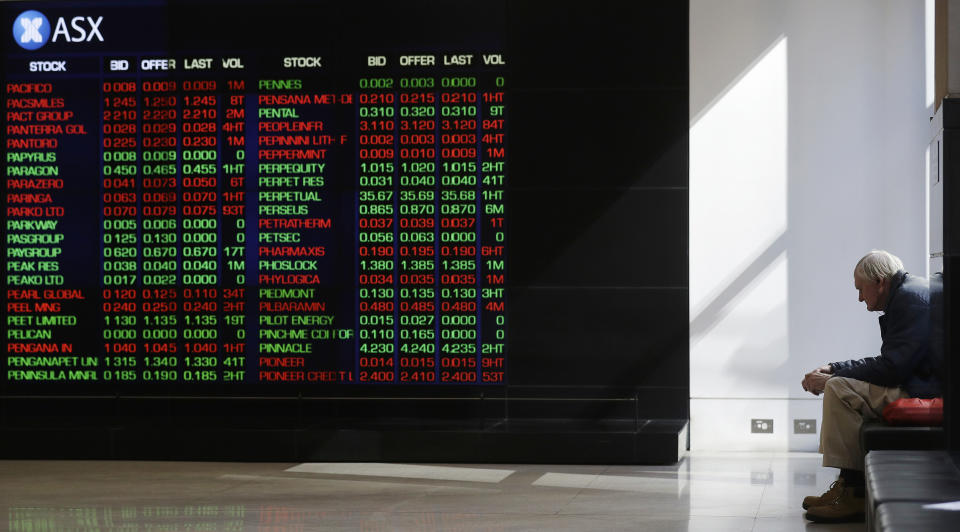 A man watches the public display boards at the Australian Stock Exchange in Sydney, Thursday, Aug. 15, 2019. Asian stock markets followed Wall Street lower on Thursday after the Dow Jones Industrial Average plunged on mounting fears of a possible recession. (AP Photo/Rick Rycroft)