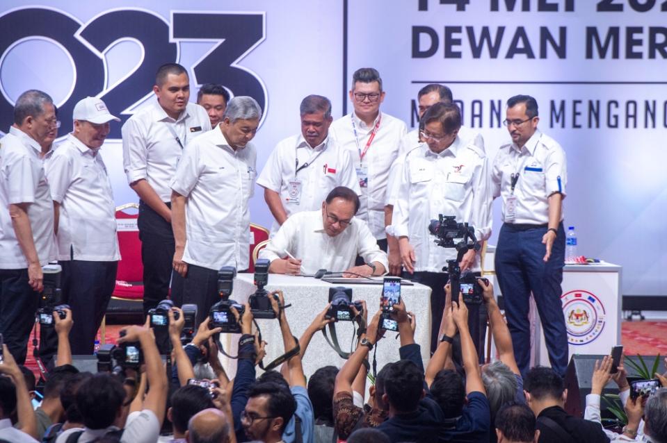 Pakatan Harapan chairman Datuk Seri Anwar Ibrahim signs the unity government resolution Unity Government National Convention at World Trade Centre Kuala Lumpur May 14, 2023. — Picture by Shafwan Zaidon