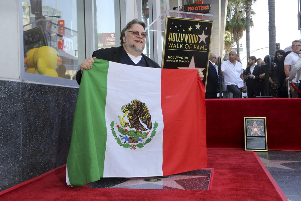 Mexican filmmaker Guillermo del Toro poses with the Mexican flag following a ceremony honoring him with a star at the Hollywood Walk of Fame on Tuesday, Aug. 6, 2019, in Los Angeles. (Photo by Willy Sanjuan/Invision/AP)