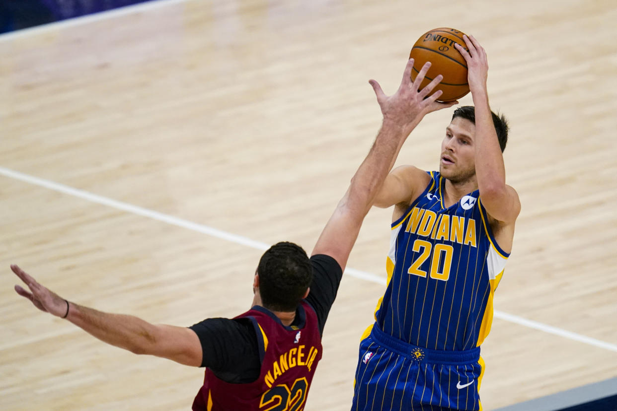 Indiana Pacers forward Doug McDermott (20) is fouled on a three-point shot by Cleveland Cavaliers forward Larry Nance Jr. (22) during the first half of an NBA basketball game in Indianapolis, Thursday, Dec. 31, 2020. (AP Photo/Michael Conroy)