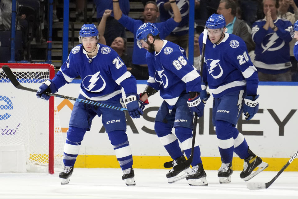 Tampa Bay Lightning right wing Nikita Kucherov (86) celebrates his goal against the Edmonton Oilers with center Brayden Point (21) and left wing Nicholas Paul (20) during the first period of an NHL hockey game Saturday, Nov. 18, 2023, in Tampa, Fla. (AP Photo/Chris O'Meara)