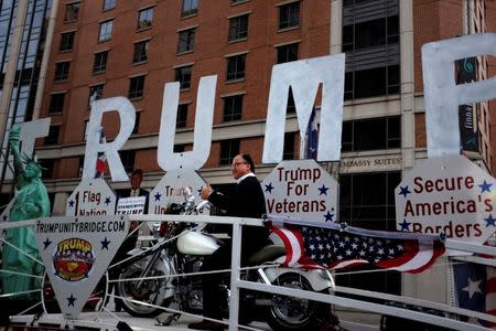 Richard Balles, deputy mayor of Johnson City, New York sits atop a motorcycle on Detroit, Michigan resident Rob Cortis' modified Trump Unity Bridge trailer in downtown Washington January 19, 2017. REUTERS/James Lawler Duggan