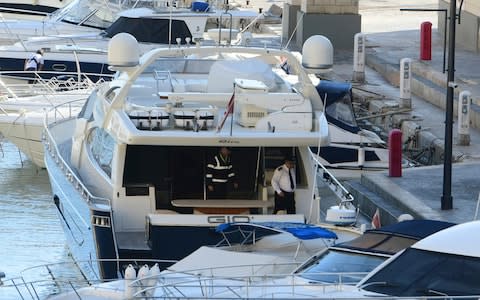 Maltese police on board Fenech's yacht after it was intercepted at sea by the Maltese military - Credit: AP