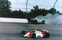 FILE - In this May 28, 1989, file photo, Emerson Fittipaldi, bottom, takes the lead with less than two laps remaining as Al Unser Jr. crashes into the wall during the 73rd running of the Indianapolis 500 auto race at Indianapolis Motor Speedway in Indianapolis, Ind. The Associated Press has updated its survey of living Indianapolis 500 winners and their pick as the greatest race in the long history of the event. There are six races that received multiple votes, topped by Al Unser Jr.’s victory over Scott Goodyear in 1992 — the closest Indy 500 in history. The others are Fittipaldi's win in 1989; Sam Hornish Junior's win in 2006; the 1982 battle between Rick Mears and Gordon Johncock; the 2011 race won by the late Dan Wheldon; and the 2014 thriller won by Ryan Hunter-Reay.(AP Photo/Ron Weaver, File)