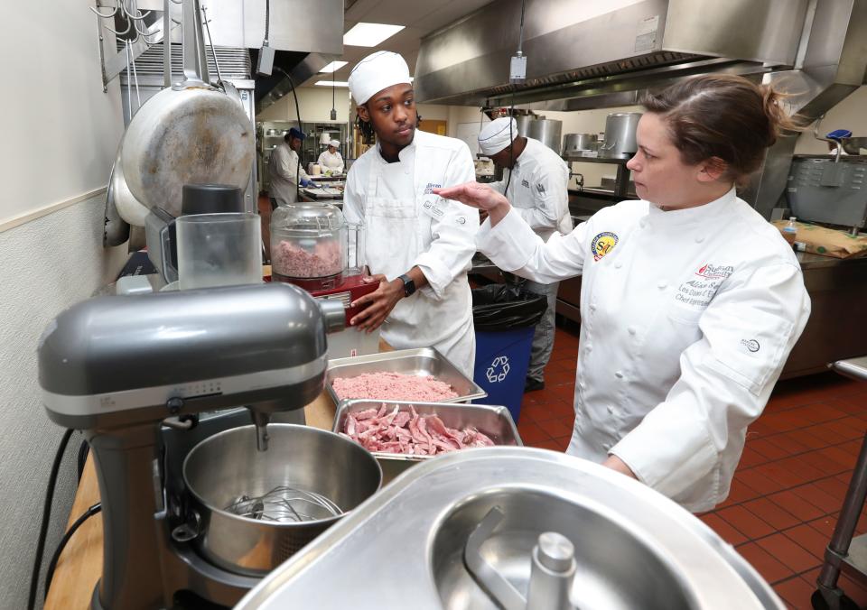 Chef Alison Settle, right, instructed Sullivan University student Cornealius Townsend as they prepare a full course meal at the school in Louisville, Ky. on Apr. 23, 2023.  The Courier Journal donated decades of archived recipes to the university which is preparing a meal using those recipes to honor the past food editors.