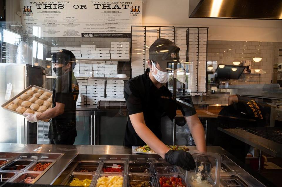 Workers make pizza at Slim & Husky’s Pizza Beeria on Tuesday, Oct. 6, 2020, in Sacramento’s Oak Park neighborhood.