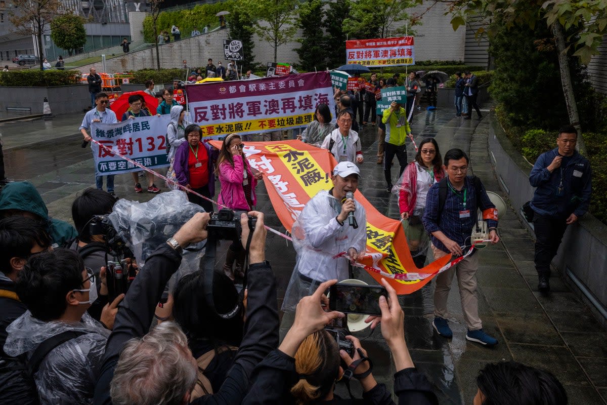File. Protesters walk within a cordon line wearing number tags during a rally in Hong Kong, 26 March 2023 (Associated Press)