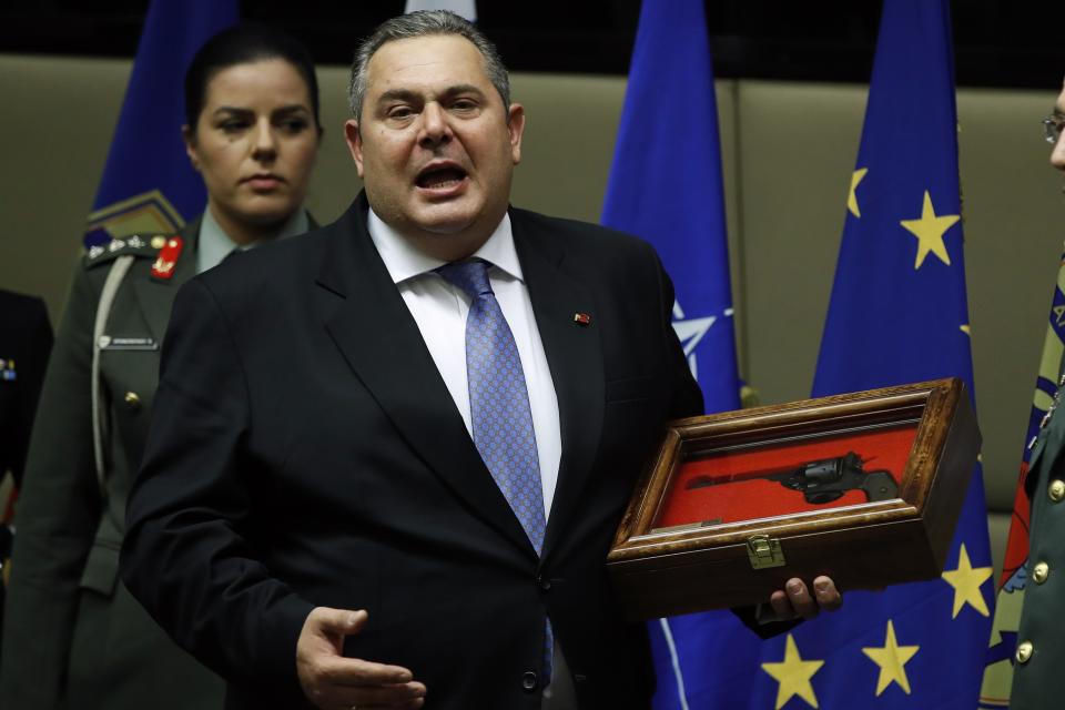 Outgoing Defense Minister Panos Kammenos receives a gift from military personnel during the handover ceremony in Athens, Tuesday, Jan. 15, 2019. Newly appointed Defense Minister Evangelos Apostolakis retired admiral left his post as head of the country's armed forces to replace Panos Kammenos, leader of a small nationalist party, who withdrew from the government coalition at the weekend over disagreement on a proposed deal between Greece and neighbor Macedonia. Greece's parliament has scheduled a confidence vote for late Wednesday following the collapse of Prime Minister Alexis Tsipras' governing coalition over a proposed deal to end a decades-old dispute with Macedonia. (AP Photo/Thanassis Stavrakis)