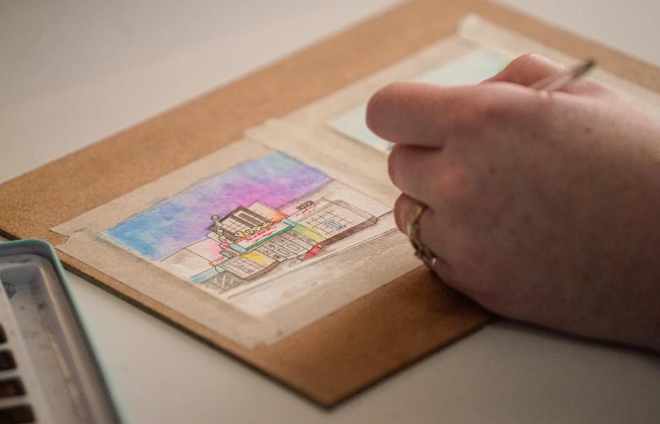 Artist Skye Lee Smith, who attended Herron School of Art + Design in Indianapolis, works on two architectural watercolor paintings, Thursday, July 28, 2022, at her Indianapolis home. Smith, who paints Indiana landmarks,  also takes commissions to paint private homes. Here she paints The Vogue Theater and the rainbow bridge in Broad Ripple Village.