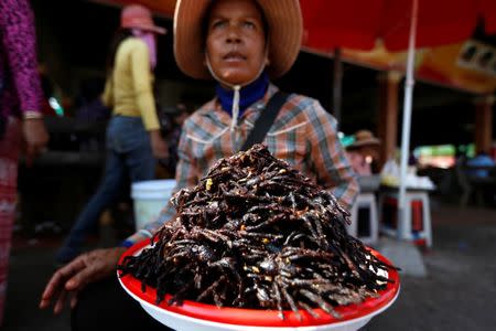 A woman sells fried tarantulas at a market in Kampong Cham province in Cambodia, April 16, 2017. REUTERS/Samrang Pring