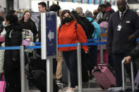 Travelers line up at a security checkpoint area in Terminal 3 at the O'Hare International Airport in Chicago, Thursday, Dec. 21, 2023. It's beginning to look a lot like a hectic holiday travel season, but it might go relatively smoothly if the weather cooperates. (AP Photo/Nam Y. Huh)