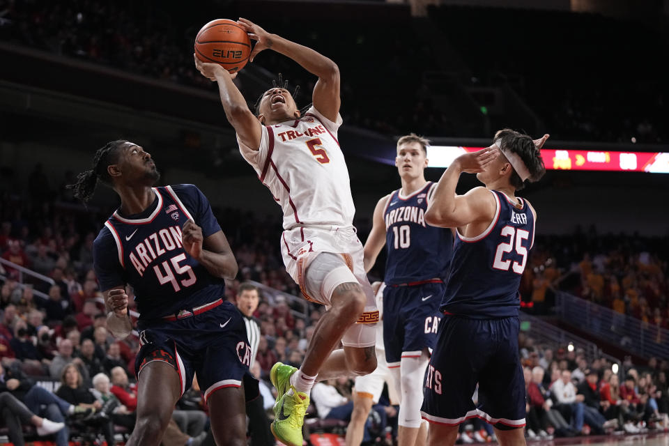 Southern California guard Boogie Ellis, second from left, shoots as Arizona guard Cedric Henderson Jr., left, forward Azuolas Tubelis, second from right, and guard Kerr Kriisa defend during the second half of an NCAA college basketball game Thursday, March 2, 2023, in Los Angeles. (AP Photo/Mark J. Terrill)