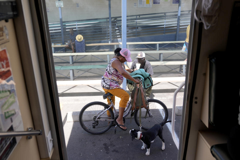 Rachel Belgrade waits with her puppy Bo outside a Circle The City mobile clinic for a blood pressure medicine prescription, Thursday, May 30, 2024 in Phoenix. Based in the hottest big metro in America, Circle the City is taking measures to protect patients from life-threatening heat illness as temperatures hit new highs. Homeless people accounted for nearly half of the record 645 heat-related deaths last year in Arizona's Maricopa County, which encompasses metro Phoenix.(AP Photo/Matt York)