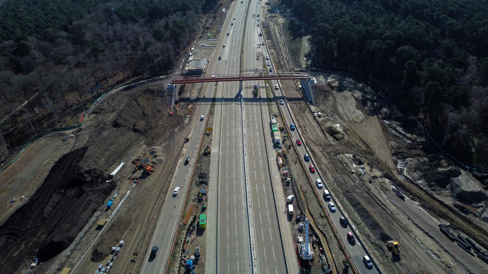 An overhead view shows vehicles (R) queuing to leave the carriageway at Junction 10 of the London orbital motorway the M25, near Cobham, south-west of London on March 16, 2024, as the motorway sees it's first total closure over a weekend since it's opening in 1986. The M25 will be closed between junctions 10 and 11 from Friday 15 March evening until Monday 18 March morning to demolish the Clearmount bridleway bridge and install a very large gantry. (Photo by Justin TALLIS / AFP) (Photo by JUSTIN TALLIS/AFP via Getty Images)