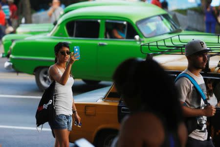 File picture: A woman uses the internet on her mobile phone at a hotspot in Havana, Cuba, July 10, 2018. Picture taken July 11, 2018. REUTERS/Stringer