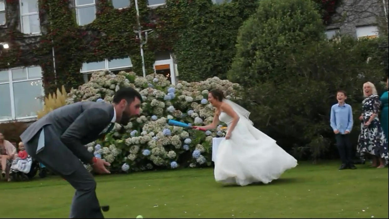 Video grab of the unfortunate moment a bride playing a game of rounders at her wedding smacked a ball - into her new husband's groin.