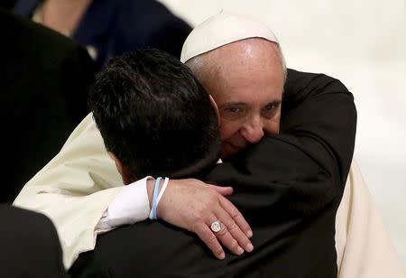 Former soccer star Diego Maradona (L) hugs Pope Francis during a special audience held before a special interreligious "Match for Peace", at the Paul VI hall at the Vatican September 1, 2014. REUTERS/Alessandro Bianchi