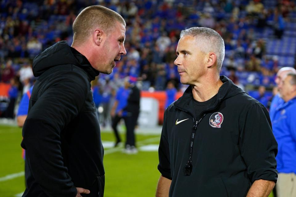 Florida coach Billy Napier, left, and Florida State coach Mike Norvell greet each other before an NCAA college football game Saturday, Nov. 25, 2023, in Gainesville, Fla. (AP Photo/John Raoux)