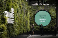 Photographers film the "living wall" inside Climate Pledge Arena, Wednesday, Oct. 20, 2021, during a media tour ahead of the NHL hockey Seattle Kraken's home opener Saturday against the Vancouver Canucks in Seattle. The historic angled roof of the former KeyArena was preserved, but everything else inside the venue, which will also host concerts and be the home of the WNBA Seattle Storm basketball team, is brand new. (AP Photo/Ted S. Warren)