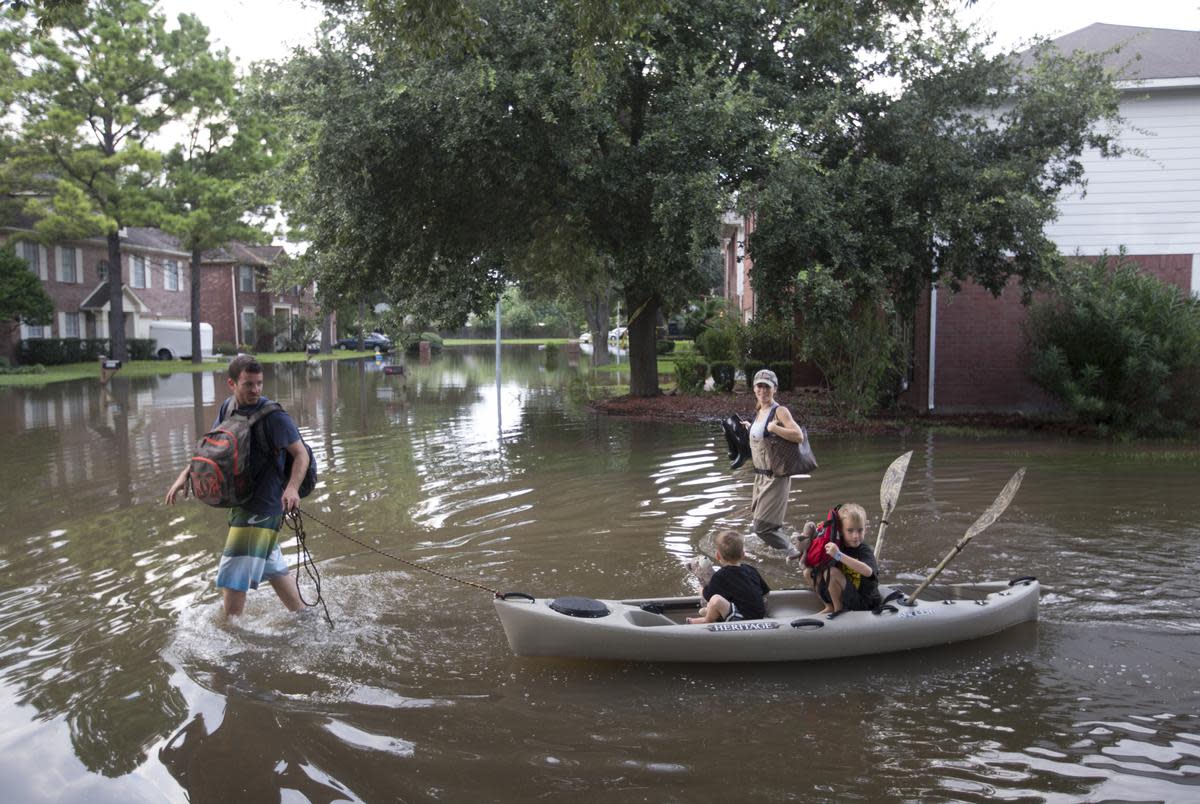 Sean and Corie Thomason take their sons Carson and Bradly back to their home via kayak on Wednesday, Aug 30, 2017, in Houston. The family stayed with their grandmother after their neighborhood was flooded by Tropical Storm Harvey.