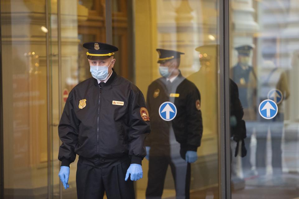 Security guards wearing face masks and gloves to protect from coronavirus, stand at an entrance of the GUM, State Department store after reopening in Moscow, Russia, on Monday, June 1, 2020. Monday's reopening of retail stores along with dry cleaners and repair shops comes as the pace of contagion has stabilized in the Russian capital that has accounted for about half of the nation's infections. (AP Photo/Alexander Zemlianichenko Jr)