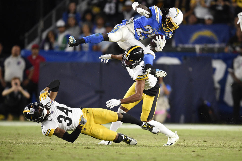 Los Angeles Chargers defensive back Rayshawn Jenkins, right, trips as he runs the ball past Pittsburgh Steelers strong safety Terrell Edmunds, left, and free safety Minkah Fitzpatrick during the first half of an NFL football game, Sunday, Oct. 13, 2019, in Carson, Calif. (AP Photo/Kelvin Kuo)