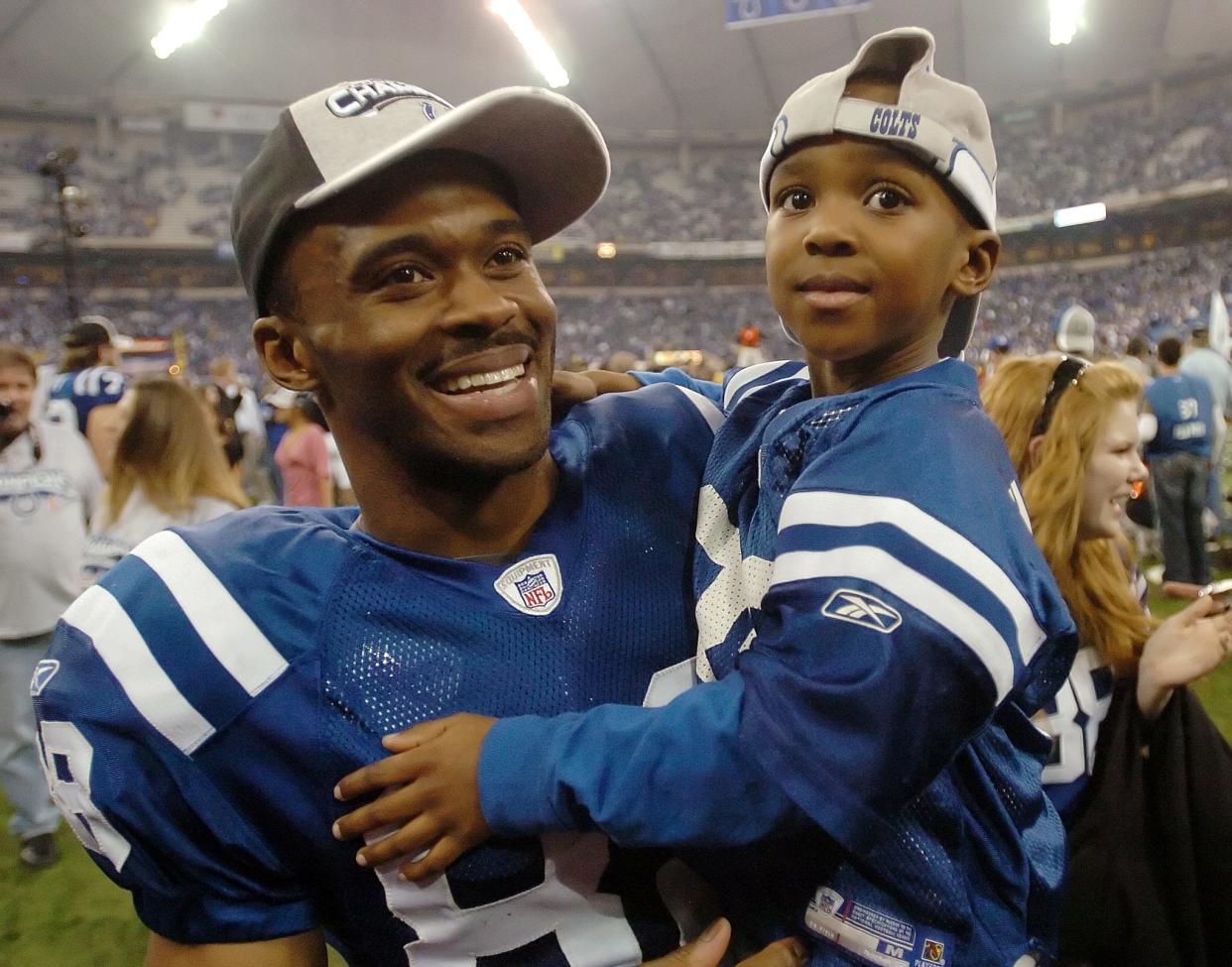 Indianapolis Colts WR Marvin Harrison smiles as he holds his son Marvin Jr. after the Colts defeated the New England Patriots 38-34 in the AFC championship game.