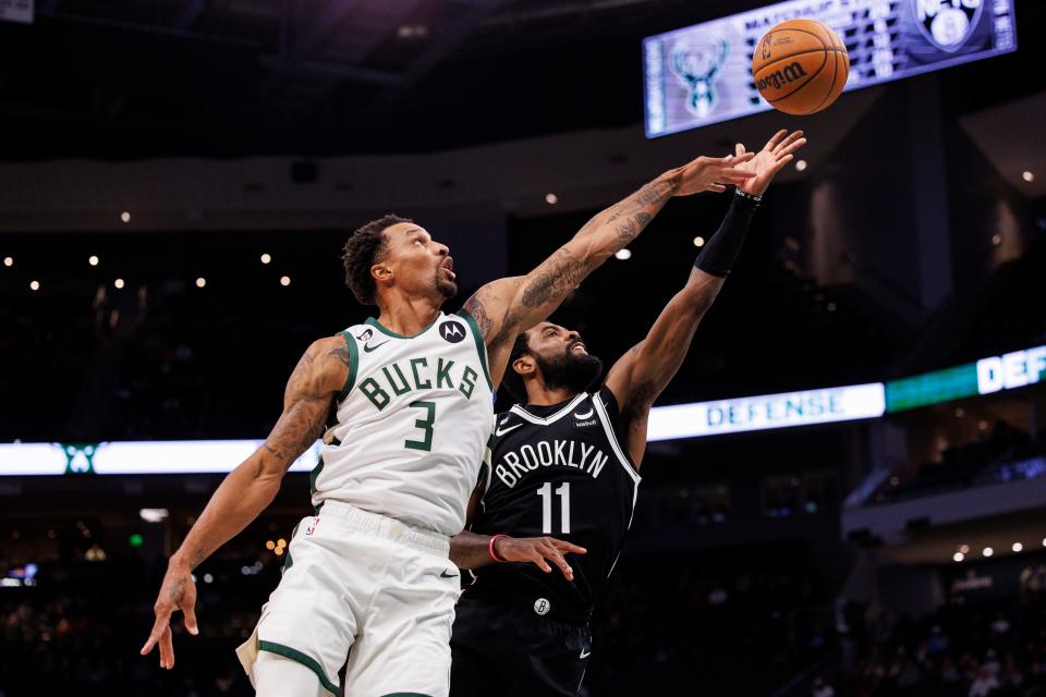 Oct 12, 2022; Milwaukee, Wisconsin, USA;  Brooklyn Nets guard Kyrie Irving (11) shoots beyond the reach of Milwaukee Bucks guard George Hill (3) during the third quarter at Fiserv Forum.