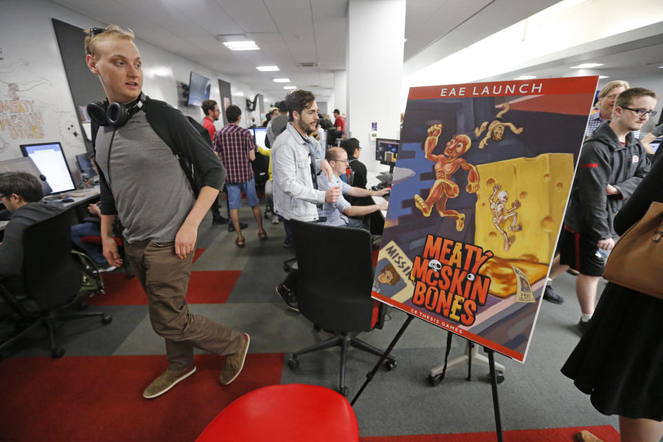 People play new video games during the Entertainment Arts and Engineering Program Launch event at the Master Games Studio on the University of Utah campus Wednesday, April 24, 2019, in Salt Lake City. Drones ferrying medical supplies, packages and even pizza could one day be crisscrossing the skies above U.S. cities, and a team at the University of Utah is working with regulators to keep that traffic in check using a video game. (AP Photo/Rick Bowmer)