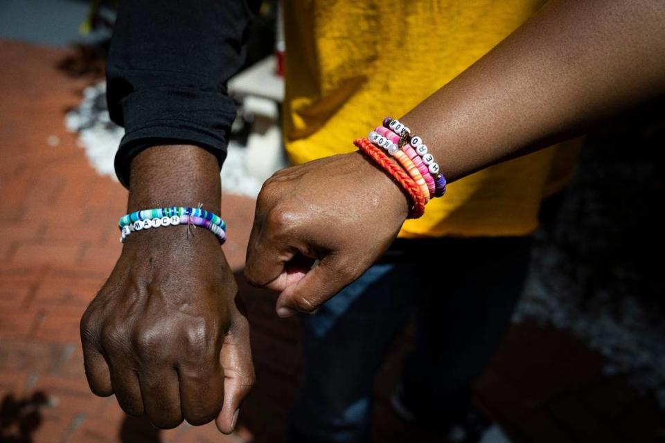 Shawn Glenn, left, and Dhima Martin, parents of Symaria Glenn, hold out their wrists to show the bracelets Symaria made for their before she died inside the Memorial Garden on Tuesday, April 9, 2024, at Memorial Regional Hospital’s Transplant Institute in Hollywood, Fla. Symaria Glenn was an organ donor, and when she died her organs saved five people, including Shawn who was awaiting a kidney transplant.