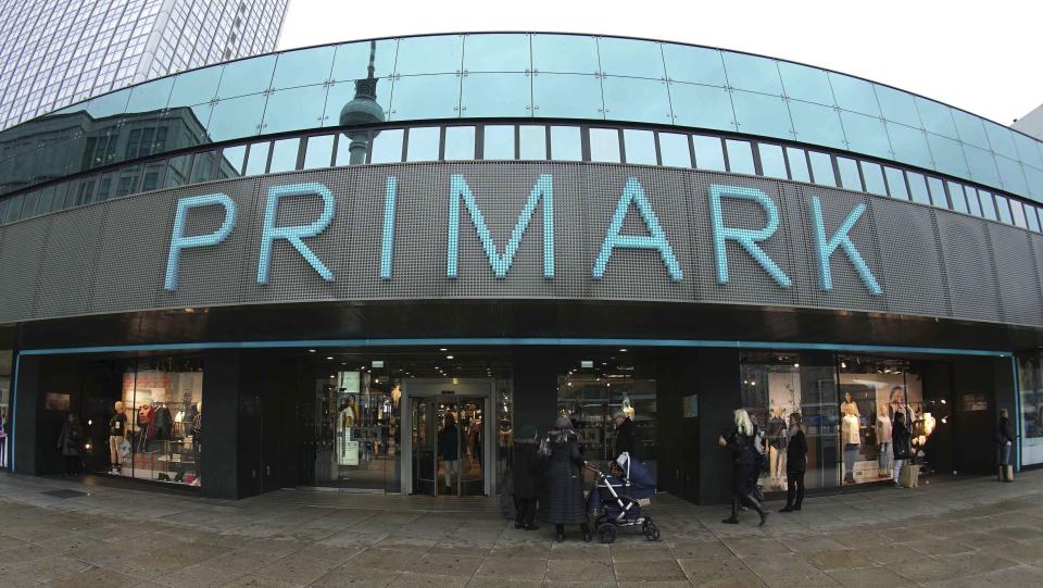 In this Thursday, Jan. 30, 2020 photo people stay in front of a Primark store at the Alexander Platz (Alexander Square) in Berlin, Germany. (AP Photo/Michael Sohn)