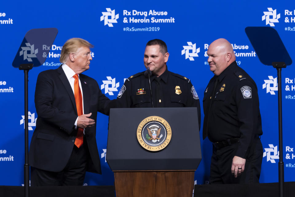 President Donald Trump, left, introduces Customs and Border Patrol officers Long and Noble to speak during the RX Drug Abuse & Heroin Summit, Wednesday, April 24, 2019 in Atlanta. The President was on hand to provide an update on the nation's opioid epidemic to elected leaders and health and law enforcement officials, about what he has called a national health emergency due to an estimated 2 million people whom are addicted to the drugs. (AP Photo/John Amis)