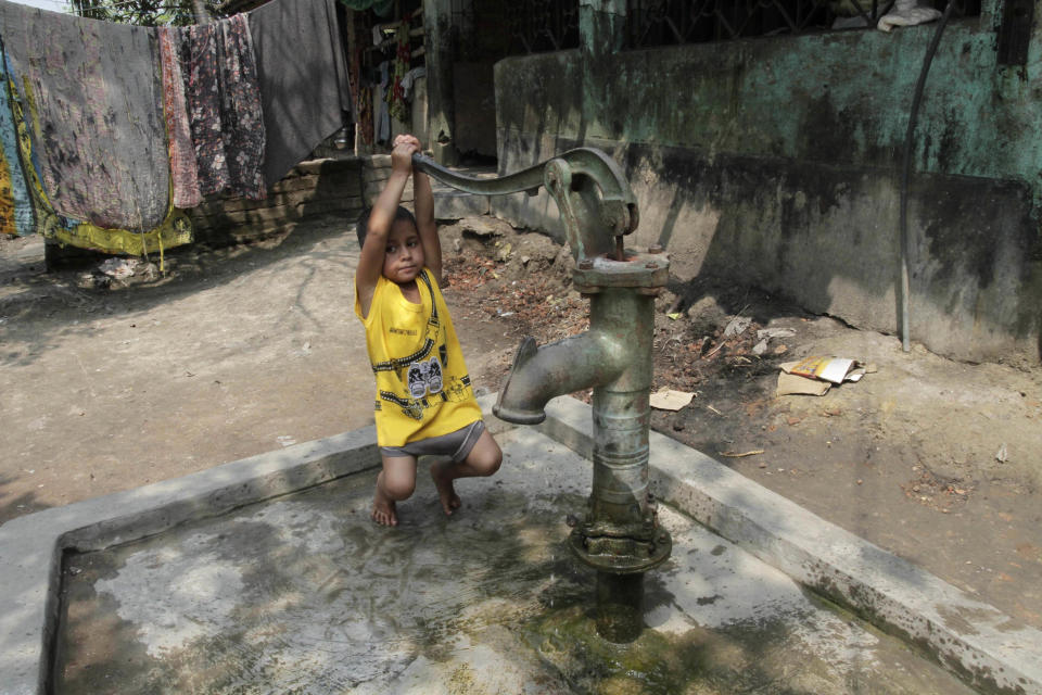 Rukhsar Khatoon, the last person in India to contract polio, hangs on the handle of a tube well in Shahpara Village, 60 kilometers (40 miles) west of Kolkata, India, Thursday, March 27, 2014. In India, the scourge of polio ends with Khatoon, a lively 4-year-old girl who contracted the disease when she was a baby after her parents forgot to get her vaccinated. On Thursday, after three years with no new cases, the World Health Organization formally declared India polio-free. (AP Photo/Bikas Das)