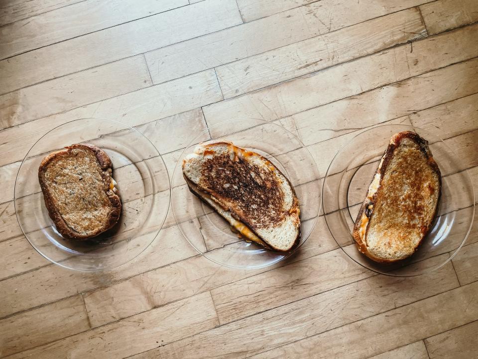 three grilled-cheese sandwiches on plates