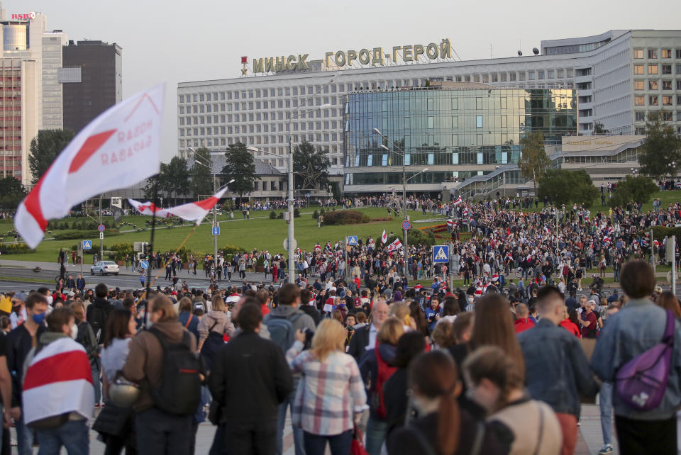 People with old Belarusian national flags gather during an opposition rally to protest the presidential inauguration in Minsk, Belarus, Wednesday, Sept. 23, 2020. Belarus President Alexander Lukashenko has been sworn in to his sixth term in office at an inaugural ceremony that was not announced in advance amid weeks of huge protests saying the authoritarian leader's reelection was rigged. Hundreds took to the streets in several cities in the evening to protest the inauguration. (AP Photo/TUT.by)