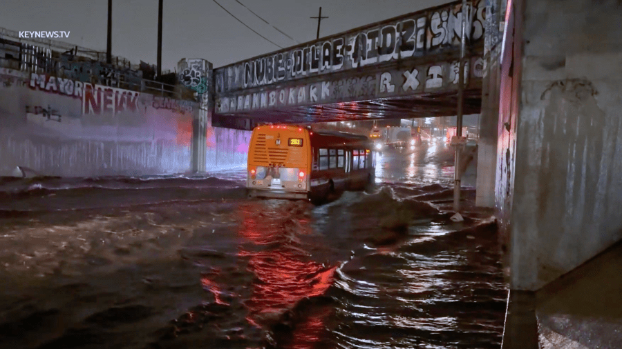 A Metro bus passes through a flooded area of Soto Street in Boyle Heights.