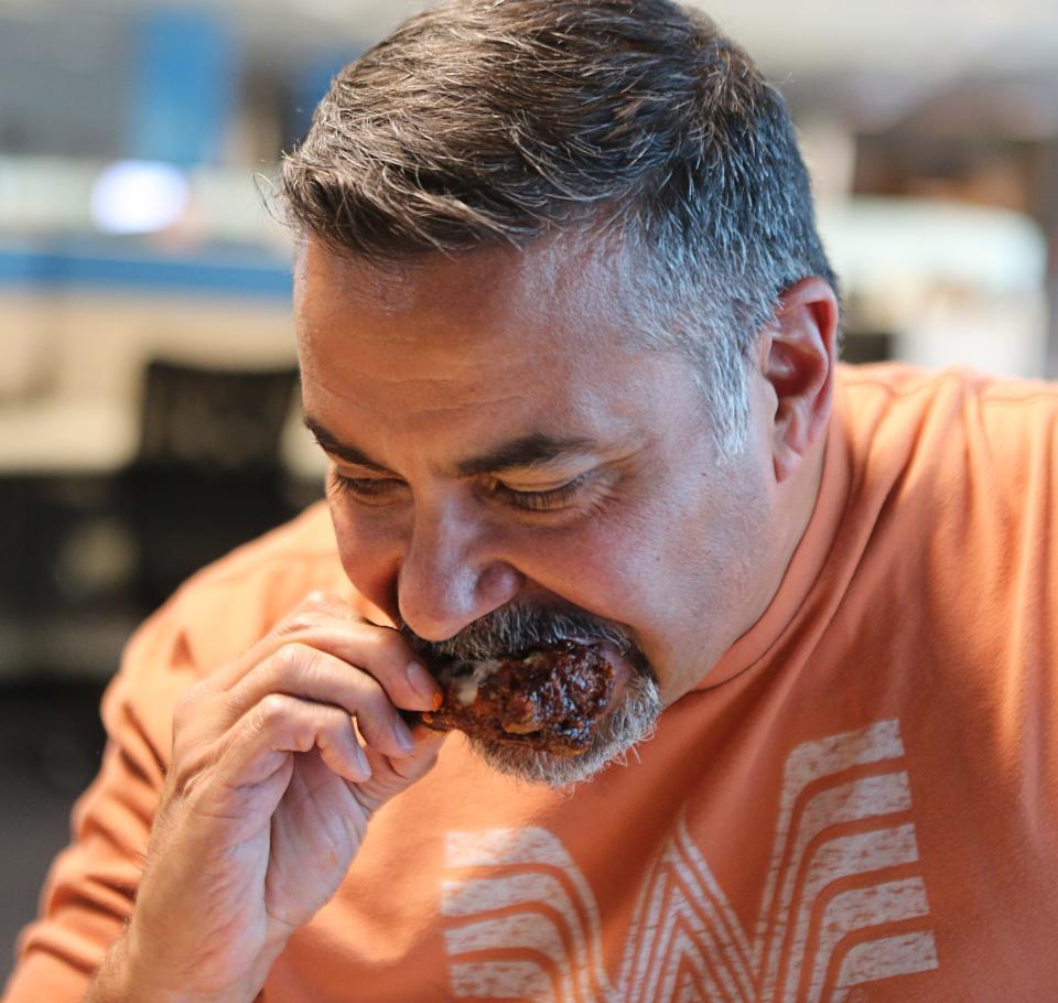 Reporter Esteban Parra samples one of the wings that made it to the final four in The News Journal's Delaware Wing Madness bracket challenge.