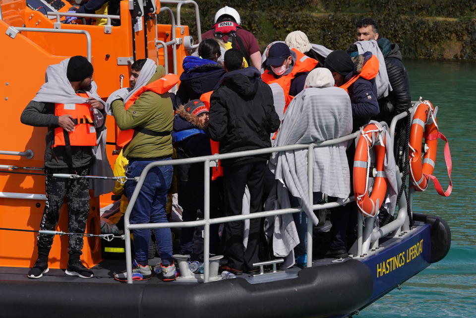 A group of people thought to be migrants are brought in to Dover, Kent, England, by the RNLI, following a small boat incident in the Channel, Thursday April 14, 2022. Britain's Conservative government has struck a deal with Rwanda to send some asylum-seekers thousands of miles away to the East African country. Opposition politicians and refugee groups are condemning the plan as unworkable, inhumane and a waste of public money. (Gareth Fuller/PA via AP)