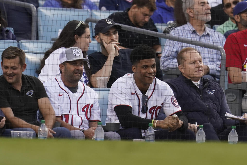 Nationals' Juan Soto, second from right, and sports agent Scott Boras, right, sit in the stands during a National League Wild Card playoff baseball game between the St. Louis Cardinals and the Los Angeles Dodgers Wednesday, Oct. 6, 2021, in Los Angeles. (AP Photo/Marcio Jose Sanchez)