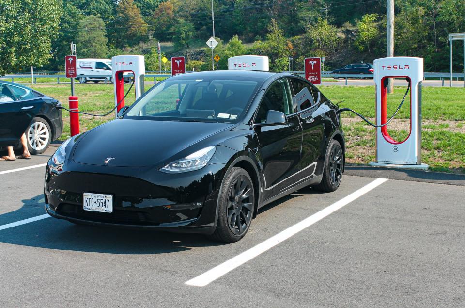 A black Tesla Model Y electric SUV in an outdoor parking space