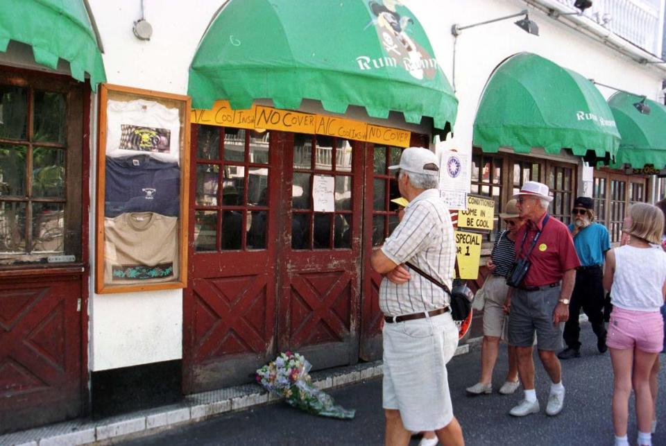 Tourists gaze at the sign taped to the door at Rumrunner’s on Duval Street. It read: “In mourning. Closed today due to death in family.” General manager Mark Sumner was shot and killed. A former bouncer is charged with the crime.