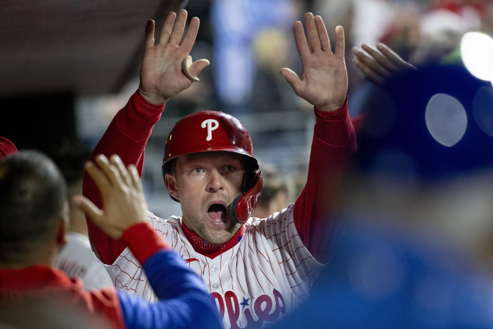 Philadelphia Phillies' Rhys Hoskins is cheered in the dugout after scoring on an RBI double by Didi Gregorius during the eighth inning of a baseball game against the New York Mets, Monday, April 11, 2022, in Philadelphia. (AP Photo/Laurence Kesterson)