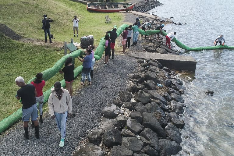Una vista aérea muestra a los voluntarios que llevan la barrera hecha a mano para bloquear el petróleo filtrado del granelero MV Wakashio el 10 de agosto de 2020
