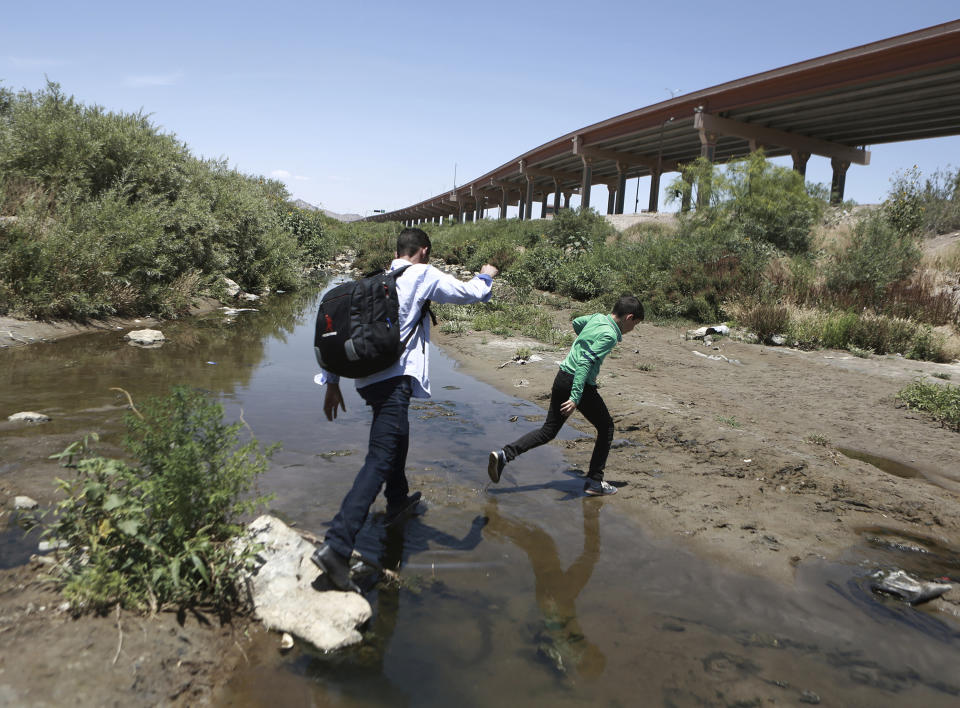 FILE - In this June 7, 2019, file photo, people cross the Rio Grande into the United States to turn themselves over to authorities and ask for asylum, as seen from Ciudad Juarez, Chihuahua, Mexico, opposite El Paso, Texas. A legal team that recently interviewed more than 60 children at a Border Patrol station in Texas warns that a traumatic situation is unfolding for some 250 infants, children and teens locked up for up to 27 days without adequate food, water and sanitation, according to a report published Thursday, June 20. (AP Photo/Christian Torres, File)